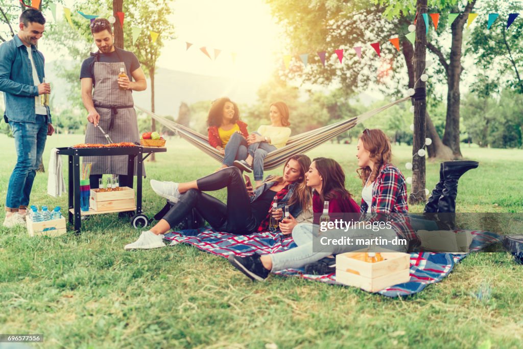 Freunde genießen ein Picknick mit Grillen im park