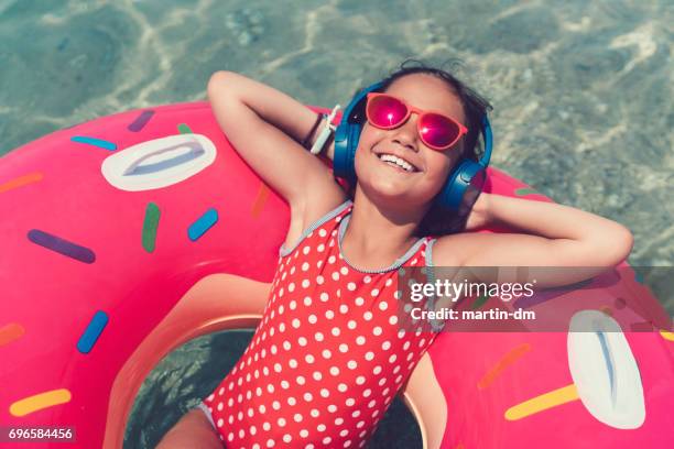 little girl in life preserver enjoying the music - girl headphones imagens e fotografias de stock