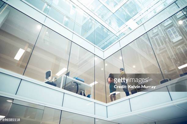 work colleagues talking in modern office - building office foto e immagini stock