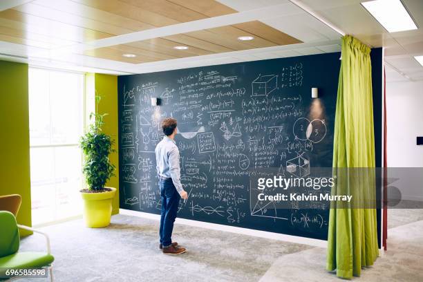 businessman working with formula on wall - best script stock pictures, royalty-free photos & images