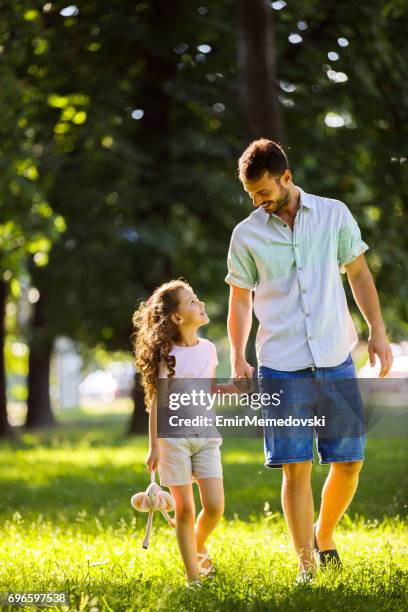 father and daughter taking a walk, holding hands - daughter dad stock pictures, royalty-free photos & images
