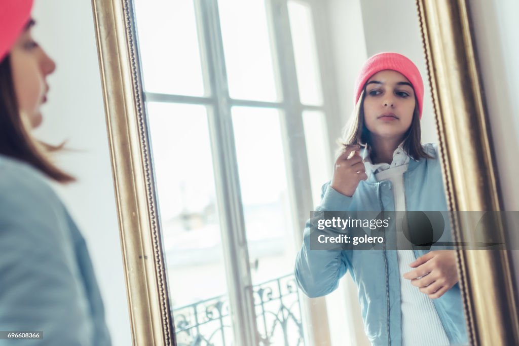 French stylish teenage girl looking herself in  mirror