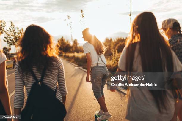 meisjes op een weg van school - alleen tieners stockfoto's en -beelden