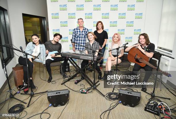 Host Elvis Duran and co-host Danielle Monaro pose with Nia Lovelis, Iain Shipp, Miranda Miller, Rena Lovelis and Casey Moreta of Hey Violet during...