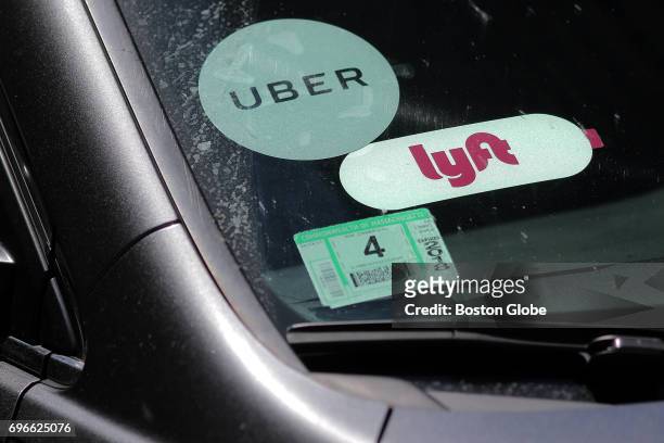 Driver with placards for both Lyft and Uber waits for a traffic light outside South Station in Boston after picking up a passenger on Jun. 15, 2017.