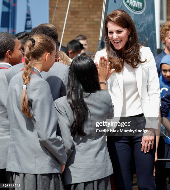 Catherine, Duchess of Cambridge high-fives a school girl as she visits the 1851 Trust roadshow at the Docklands Sailing and Watersports Centre on...