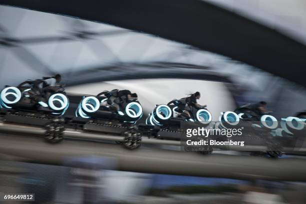 Visitors ride the TRON Lightcycle Power Run roller coaster attraction during the one-year celebration of Walt Disney Co. Shanghai Disneyland resort...