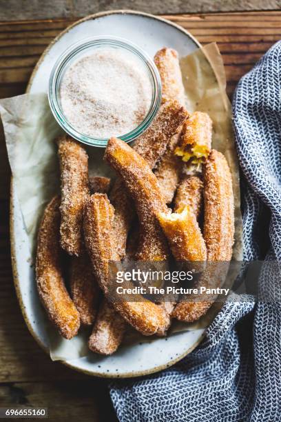 a churro, a fried dough sweet pastry based snack. - churro stockfoto's en -beelden