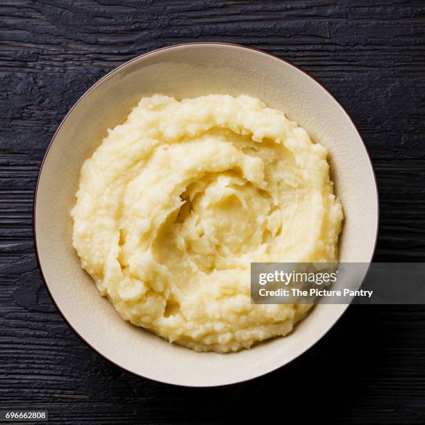 mashed potatoes in bowl on burned black wooden background - prepared potato stock pictures, royalty-free photos & images