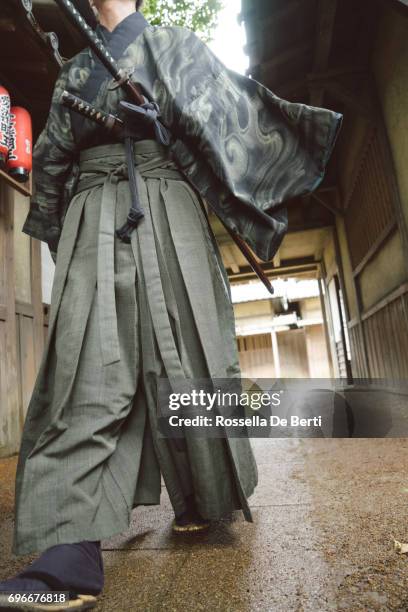 samurai warrior walking through a traditional japanese village - sword stock pictures, royalty-free photos & images