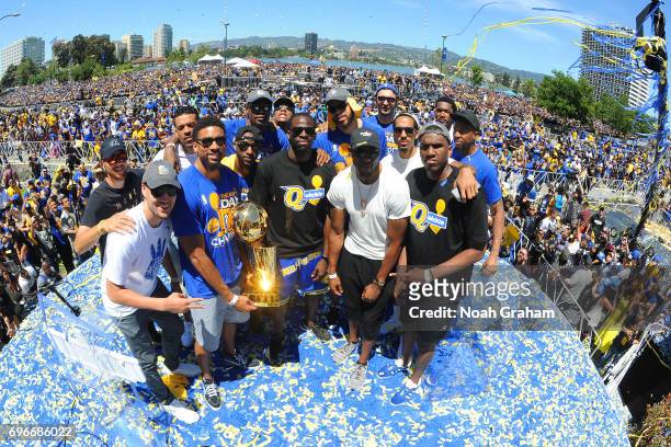 The Golden State Warriors hold up the Larry O'Brien Trophy during the Victory Parade and Rally on June 15, 2017 in Oakland, California at The Henry...