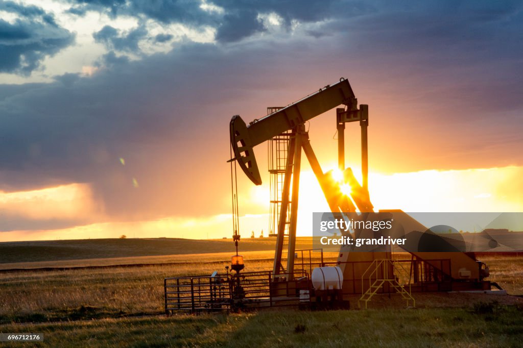 Fracturamiento hidráulico de la bomba Jack al atardecer con puesta de sol