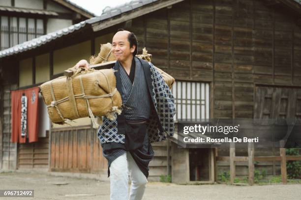 japanse man die zijn handel goederen vervoeren, edo periode dorp - edoperiode stockfoto's en -beelden