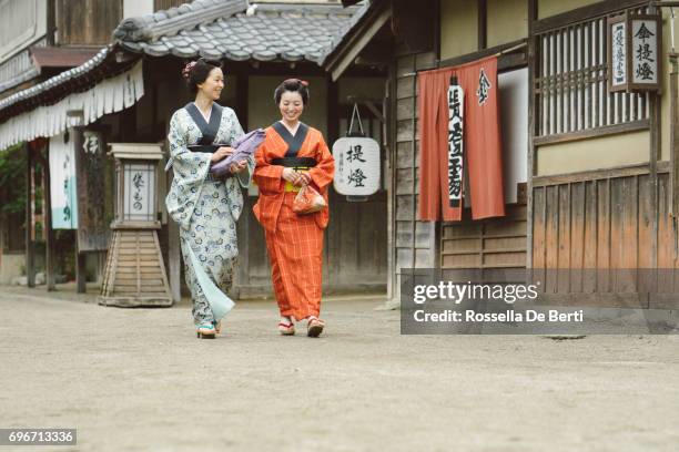 beautiful japanese women wearing kimono walking in old village, edo period - track town classic 2016 stock pictures, royalty-free photos & images