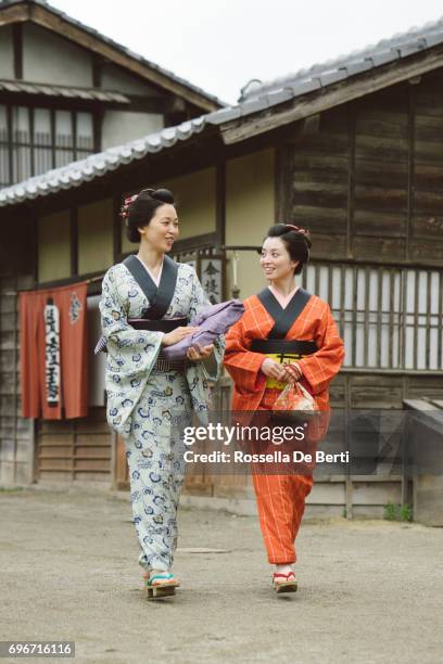 beautiful japanese women wearing kimono walking in old village, edo period - track town classic 2016 stock pictures, royalty-free photos & images