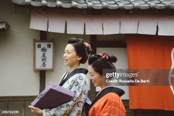 beautiful japanese women wearing kimono walking in old village, edo period - track town classic 2016 stock pictures, royalty-free photos & images