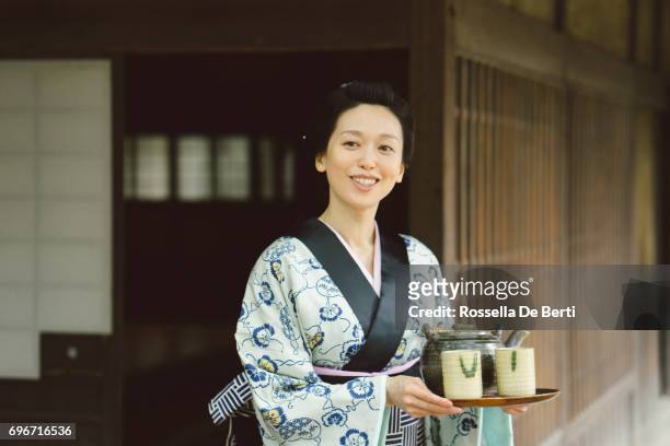 japansk kvinna med tebricka utanför en traditionella japanska hus, edo-perioden - teceremoni bildbanksfoton och bilder