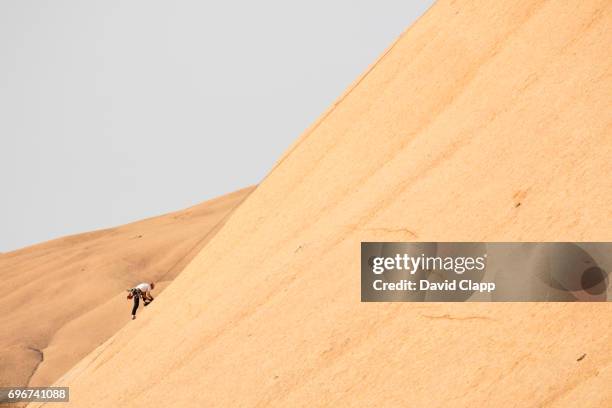 climber on a steep granite slope at spitzkoppe in namibia - steep stock pictures, royalty-free photos & images