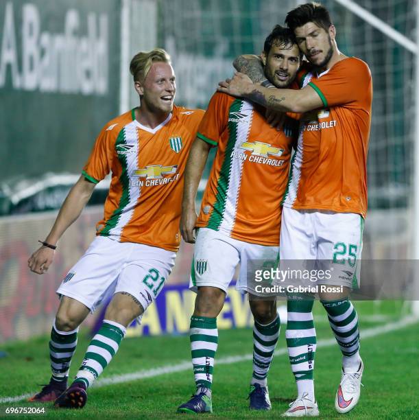 Dario Cvitanich of Banfield celebrates with teammates Carlos Matheu and Thomas Rodríguez after scoring the third goal of his team during a match...