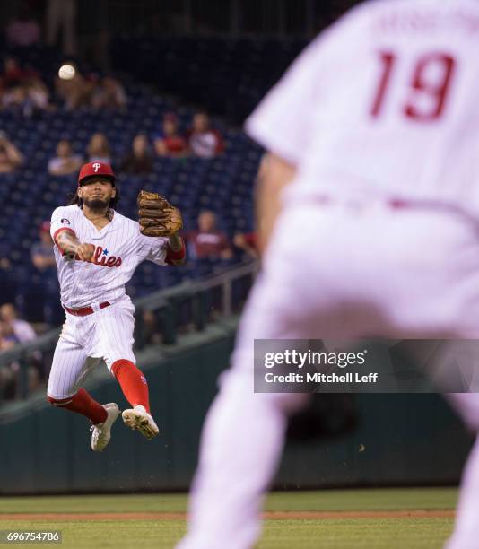 Freddy Galvis of the Philadelphia Phillies throws the ball to Tommy Joseph of the Philadelphia Phillies in an unsuccessful attempt to get out Jeremy...