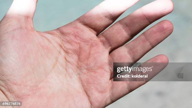 close up shot of palm side of man's hand partly illuminated by sunbeam - handfläche stock-fotos und bilder