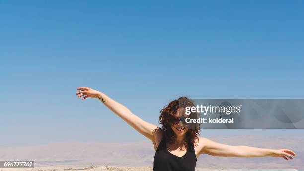 woman pretending flying against blue sky - 飛行機のまね ストックフォトと画像