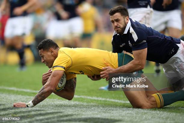 Israel Folau of the Wallabies score try as he is tackled by Alex Dunbar of Scotland during the International Test match between the Australian...