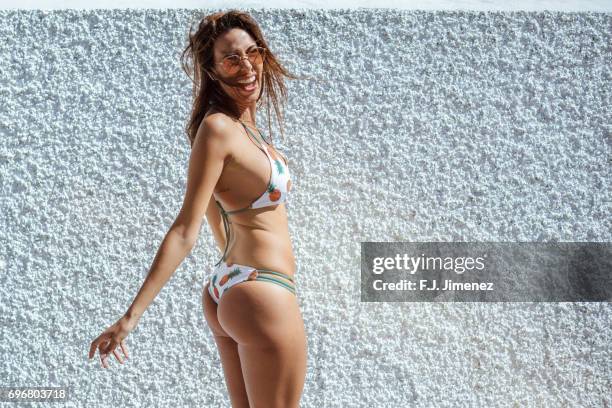 beautiful woman in bikini in front of white wall - thongs stock-fotos und bilder