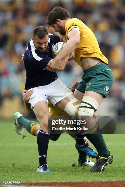 Rory Hughes of Scotland is tackled by Scott Higginbotham and Sam Carter of the Wallabies during the International Test match between the Australian...