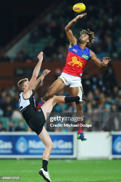 Archie Smith of the Lions taps the ball away from Jackson Trengove of the Power during the round 13 AFL match between the Port Adelaide Power and the...