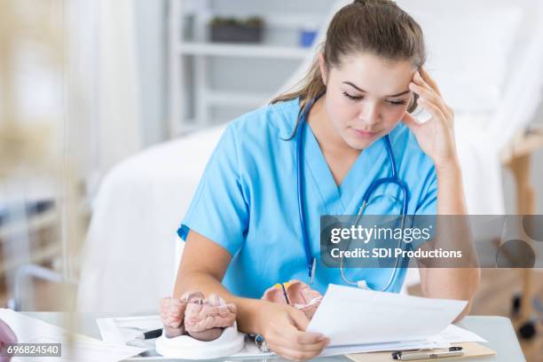 focused medical intern studies patient file - nurse thinking stock pictures, royalty-free photos & images