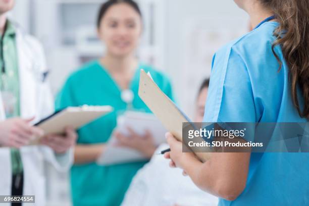 geneeskundestudenten in patiënt ziekenhuis kamer - gezondheidszorg en medicijnen stockfoto's en -beelden