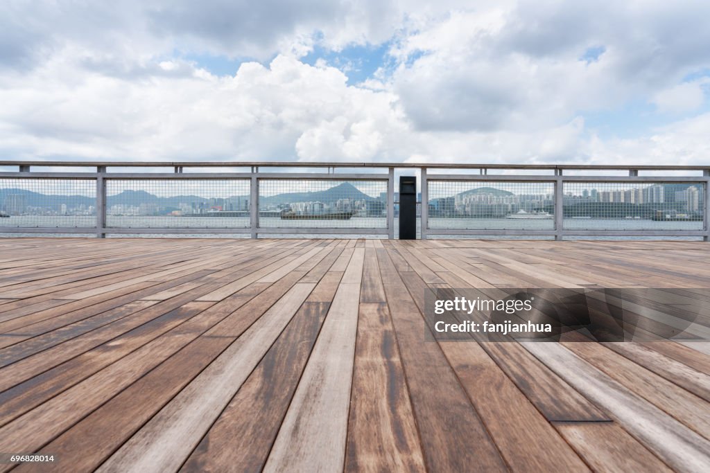 Empty wooden platform with Hong Kong skyline in background