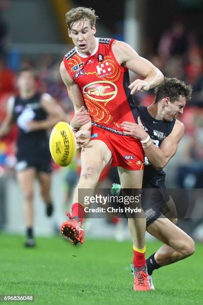 Tom Lynch of the Suns is tackled by Kade Simpson of the Blues during the round 13 AFL match between the Gold Coast Suns and the Carlton Blues at...