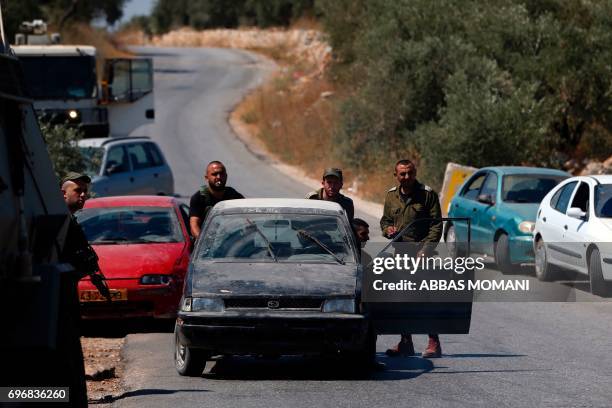 Israeli soldiers confiscate vehicles from the village of Deir Abu Mashal near the West Bank city of Ramallah, on June 17 following an attack by three...