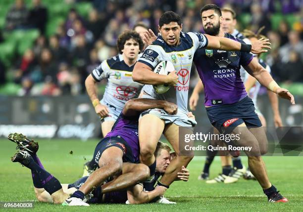 Jason Taumalolo of the Cowboys is tackled during the round 15 NRL match between the Melbourne Storm and the North Queensland Cowbpys at AAMI Park on...