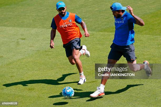 India's captain Virat Kohli and India's Umesh Yadav play football during a nets practice session at The Oval in London on June 17 on the eve of the...