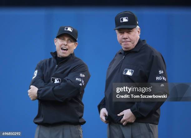 Second base umpire Tripp Gibson talks to first base umpire Brian Gorman during a break in the action of the Toronto Blue Jays MLB game against the...