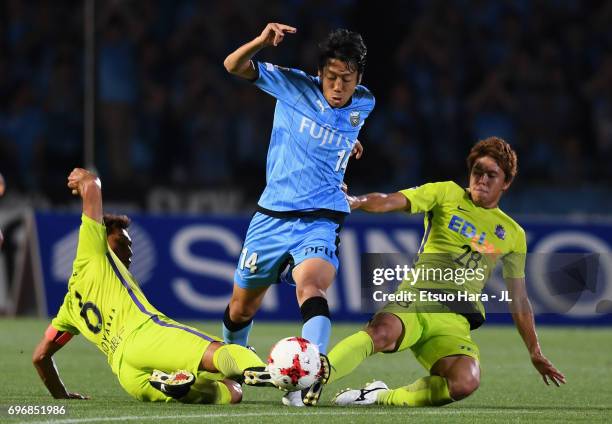 Kengo Nakamura of Kawasaki Frontale is tackled by Toshihiro Aoyama and Takuya Marutani of Sanfrecce Hiroshima during the J.League J1 match between...