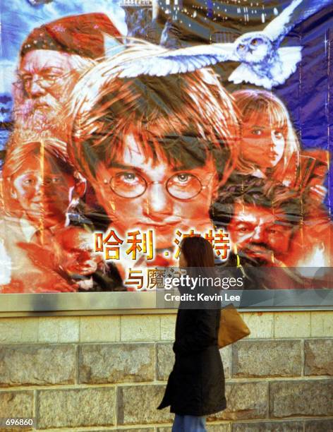 Chinese woman passes by a Harry Potter movie billboard February 1, 2002 during the first public opening in Beijing, China. More than three million...