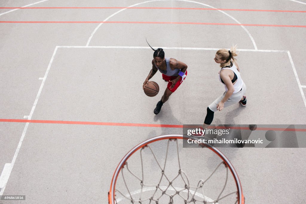 Frau Dribling und Basketball spielen mit Freund