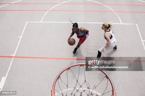 frau dribling und basketball spielen mit freund - womens basketball stock-fotos und bilder