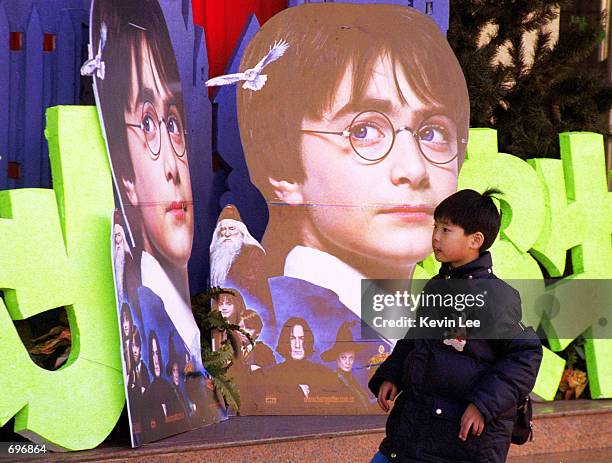 Young child looks at a Harry Potter movie poster in front of a movie theater February 1, 2002 in Beijing, China. More than three million copies of...