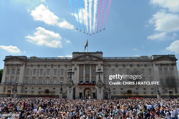 Crowds gather outside the gates as members of the Royal Family stand on the balcony of Buckingham Palace to watch a fly-past of aircraft by the Royal...