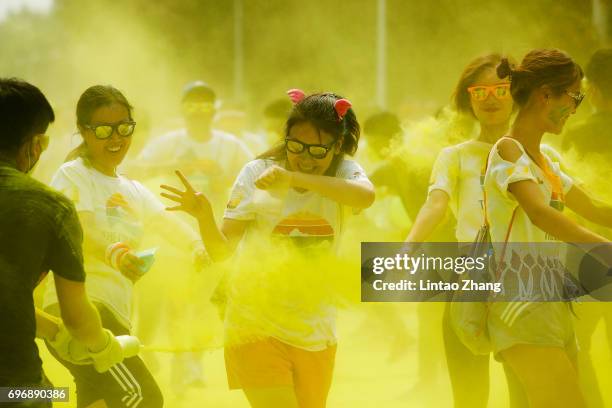 Competitors run through the yellow colour station during the Colour Run at the Beijing International Garden Expo park on June 17, 2017 in Beijing,...