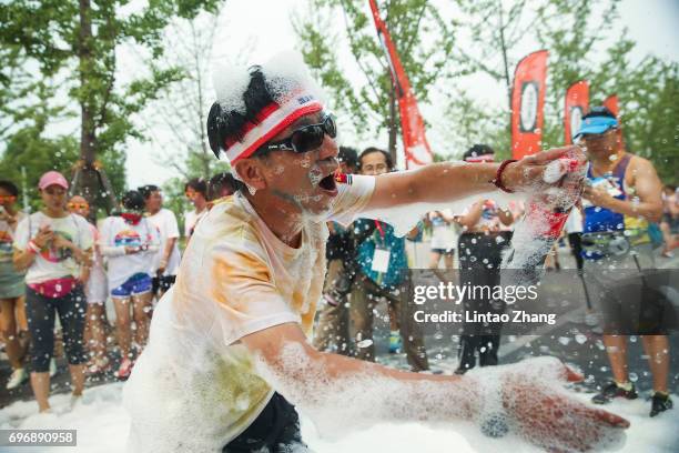 Competitors playing with soap bubbles during the Colour Run at the Beijing International Garden Expo park on June 17, 2017 in Beijing, China.