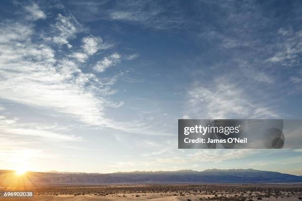 sunset over open plane with distant mountains and large sky - himmel stock-fotos und bilder