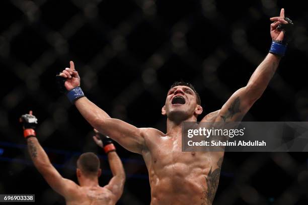 Rafael dos Anjos of Brazil and Tarec Saffiedine of Belgium reacts at the end of the Welterweight Bout during UFC Singapore Fight Night at Singapore...