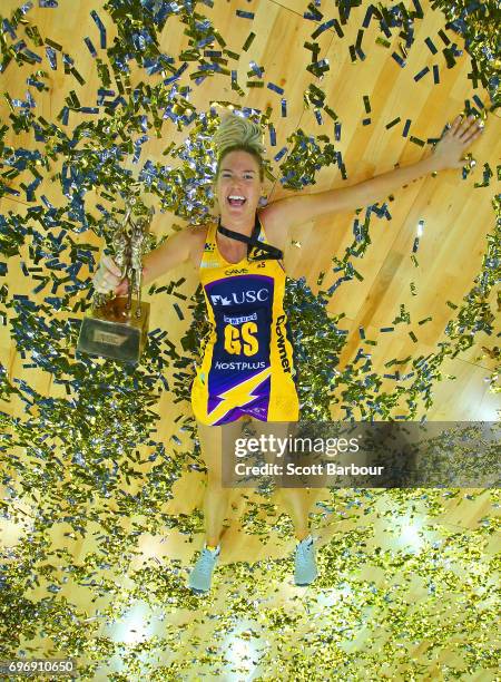 Caitlin Bassett of the Lightning celebrates victory amongst the confetti while holding the Suncorp Super Netball trophy after winning the Super...