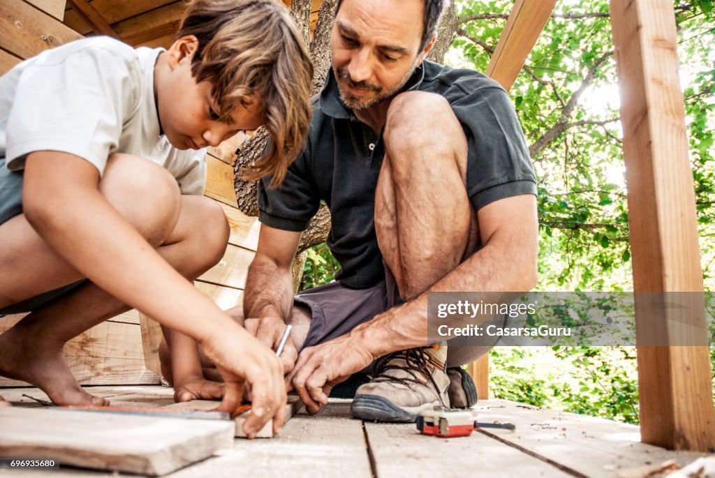 Vater und Sohn gemeinsam ein Baumhaus bauen